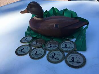 a duck decoy surrounded by medals