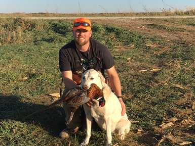 Man with dog holding pheasant